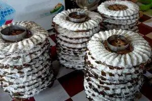 From above of white noodle placed on wooden caps and drying on tile floor in manufacture in light place