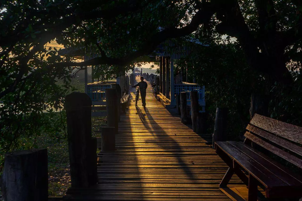 Cyclist on a Mandalay jetty at golden hour representing the authentic travel experience available for visitors in 2026