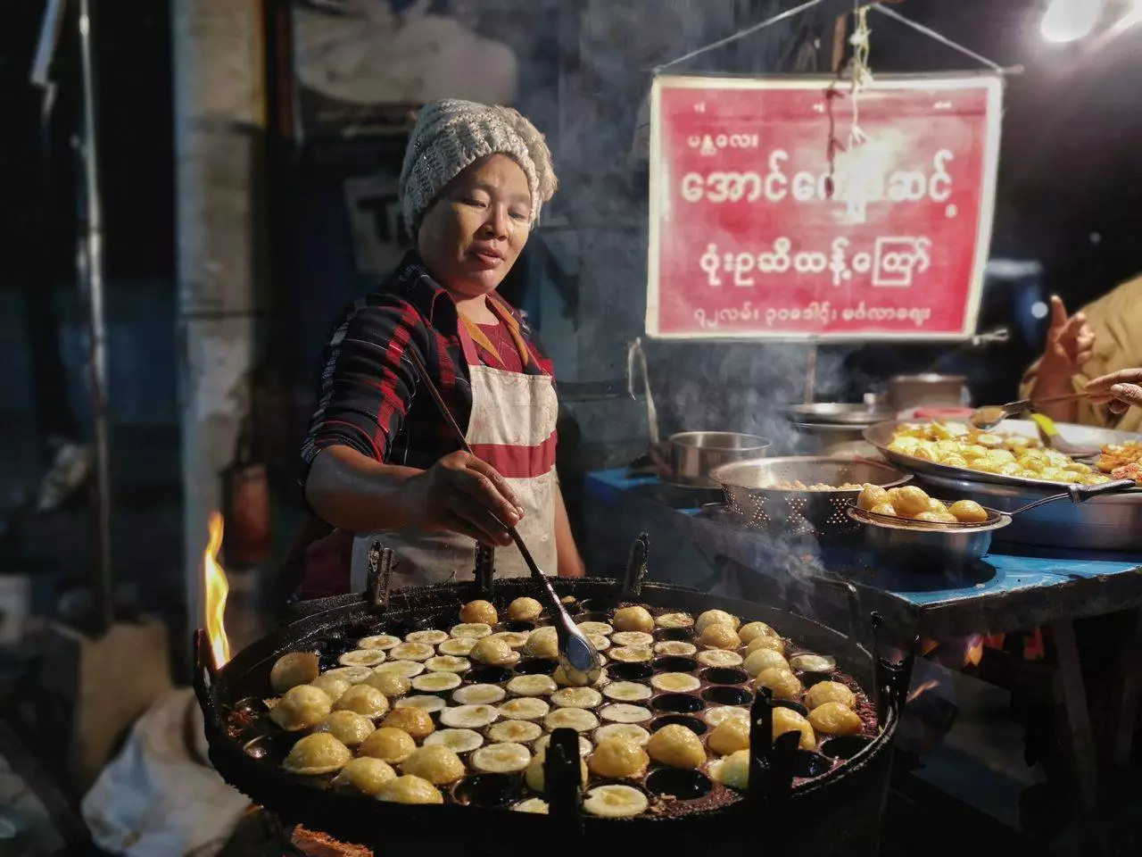 Street food cook at Mandalay market representing where to find the best authentic Htoe Mont traditional Burmese sweets