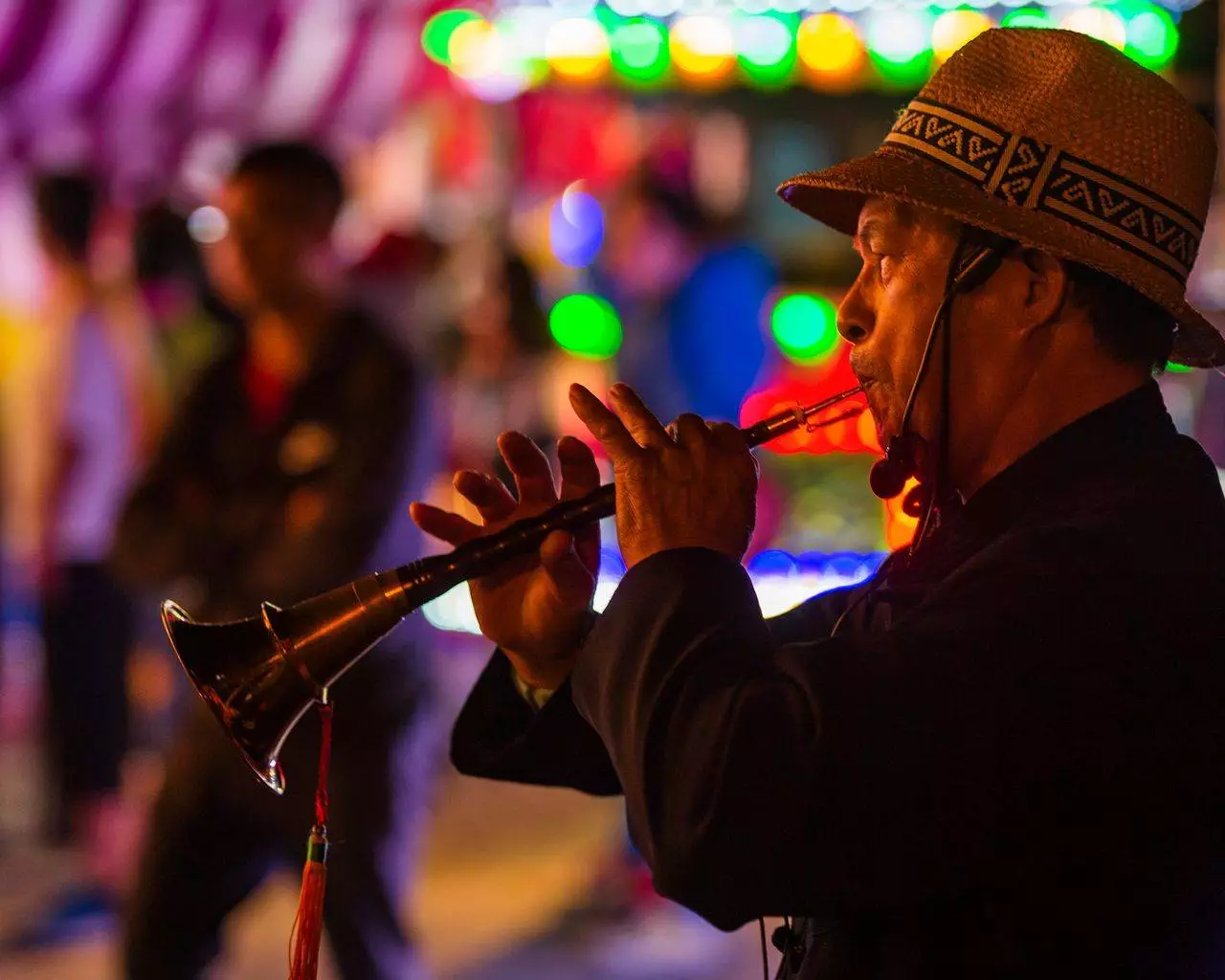 Musician playing traditional instrument at a night festival representing Mandalay Saing Waing performances and cultural shows